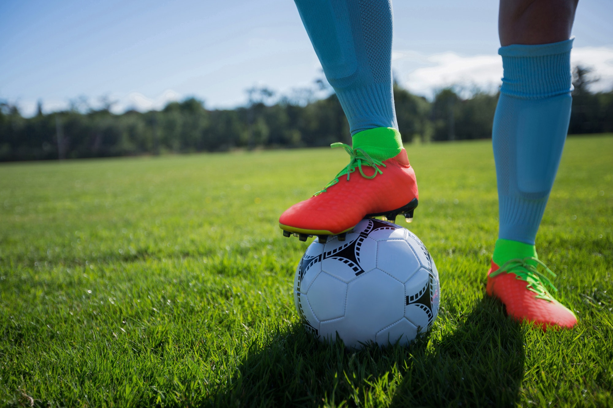 Football player standing with soccer in the ground