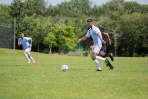 Football players playing soccer in the ground