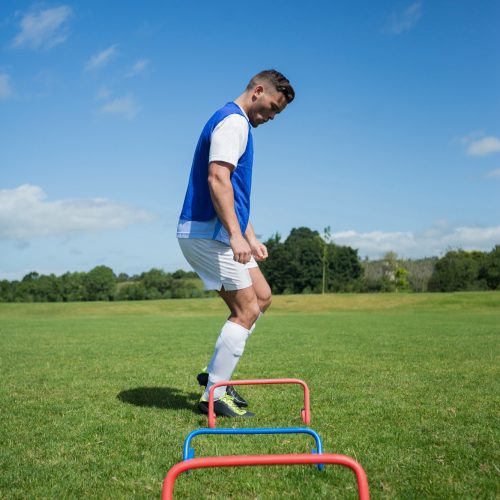 Soccer player practicing on obstacle